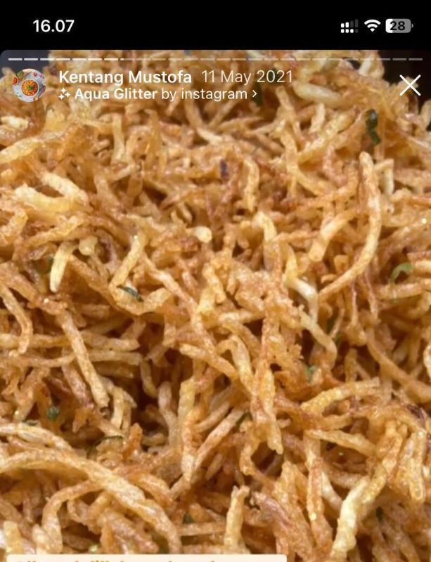 Ibu karier modern yang tersenyum lega dengan piring berisi Kentang Mustofa Mulya Cuisine di meja makan bersama keluarga, menyoroti kemudahan dan kesehatan lauk cepat saji